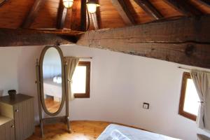 a bedroom with a mirror and a wooden ceiling at Kefalonian Mill - Oneira Villas in Trapezaki