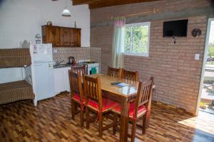 a kitchen with a wooden table with chairs and a refrigerator at Las nenas in La Falda