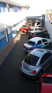 a row of cars parked in a parking lot at Raízes Hotel in Cajobi