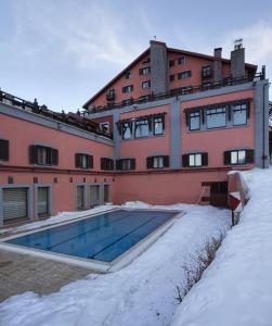 ein Gebäude mit einem Pool im Schnee in der Unterkunft Dedeman Palandoken Ski Lodge Hotel in Erzurum