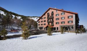 ein großes Gebäude im Schnee mit Bäumen davor in der Unterkunft Dedeman Palandoken Ski Lodge Hotel in Erzurum