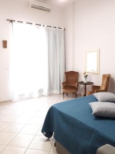 een slaapkamer met een bed met een blauwe deken bij Casa Mia Miniapartment in Riposto