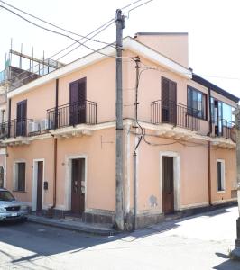 een perzikkleurig gebouw met balkons in een straat bij Casa Mia Miniapartment in Riposto