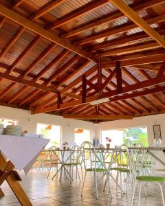 Chalé Alto da Serra SP في سيرا نيجرا: غرفة طعام بسقوف خشبية وطاولات وكراسي