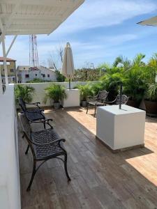 patio z 2 krzesłami i parasolem w obiekcie KSL Residence w mieście Boca Chica