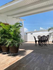 een patio met 4 stoelen, een tafel en planten bij KSL Residence in Boca Chica