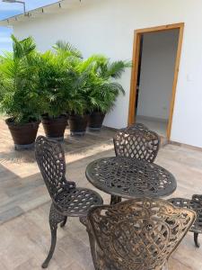 a patio with a table and chairs and potted plants at KSL Residence in Boca Chica