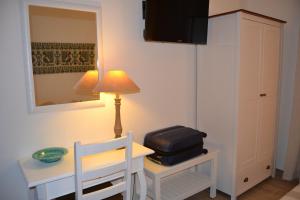 ヌーオロにあるNuscos Bed and Breakfastのテーブル、椅子、ランプが備わる部屋