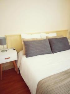 a bedroom with a white bed and a nightstand with a bed sidx sidx sidx at Villa Regio Garden in Vila do Conde