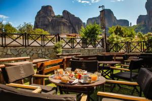 卡蘭巴卡的住宿－Tsikeli Boutique Hotel Meteora - Adults Friendly，餐厅配有桌椅,位于山脉的背景中