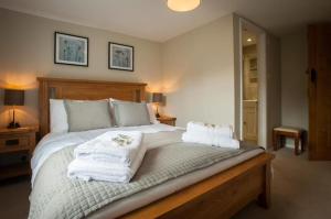 a bedroom with a large bed with towels on it at Westgate Lodge at Dedham in Dedham