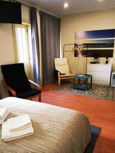 a hotel room with a bed and two chairs and a mirror at Villa Regio Garden in Vila do Conde