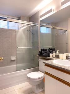 y baño con ducha, aseo y lavamanos. en Perfect Location - Tidy & Comfy Suite 5 Mins to Skytrain & Restaurant & Banks, 2 Stops To Metrotown, 5 Stops To Downtown, en Vancouver