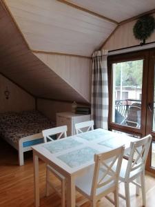 a room with a table and chairs and a bed at Willa Rosiczka in Okuninka