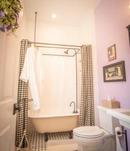 a bathroom with a bath tub and a toilet at Hill of Content B&B in Radiant