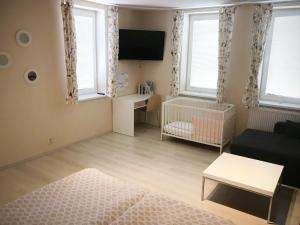 - un salon avec un canapé et un lit bébé dans l'établissement Apartmán 501, à Važec