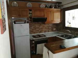 a kitchen with a white refrigerator and a sink at Casa Henni in Els Poblets