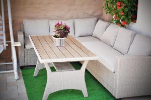 a wicker couch and a table with flowers on it at Apartmán 501 in Važec