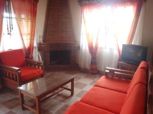 a living room with a red couch and a fireplace at Cabañas Sierra Verde in Zacatlán