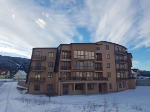 a large building with snow on the ground at Apartman Panorama in Kupres