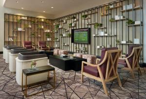 a lobby with couches and chairs and a television at Hyatt Regency Houston West in Houston