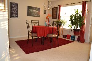 Cascade Comfort في أتلانتا: طاولة غرفة الطعام مع كراسي على سجادة حمراء