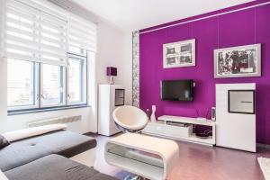 salon z fioletową ścianą w obiekcie Apartment Bubenikova w mieście Pardubice