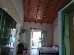 Schlafzimmer mit einem Bett und einer Tür zu einer Terrasse in der Unterkunft Lenia Studios in Kalamitsi
