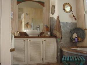 uma casa de banho com um lavatório e um espelho em la maison de Carol em Le Beausset