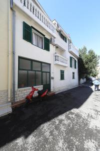 una casa con una moto roja estacionada frente a ella en Apartments Vedrana en Biograd na Moru