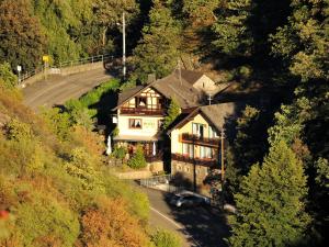 una casa en una colina con un coche aparcado delante en Hotel Café Herrmanns Mühle en Sankt Goarshausen