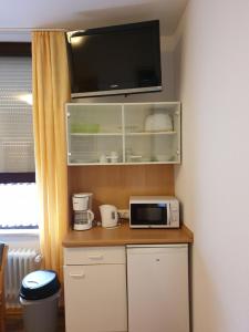 a kitchen with a microwave and a tv on a shelf at Central Wohnen in Wilhelmshaven