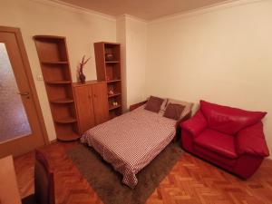 un soggiorno con divano e sedia rossa di Spacious quiet apartment next to Arena Armeec and Metro station GM Dimitrov a Sofia