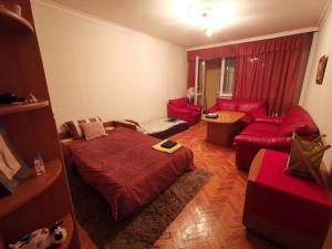 un soggiorno con mobili rossi e un divano rosso di Spacious quiet apartment next to Arena Armeec and Metro station GM Dimitrov a Sofia