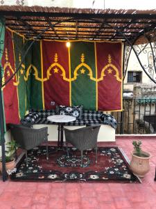 d'une terrasse avec une table et des chaises en toile de fond. dans l'établissement Dar benelmahi, à Fès
