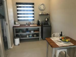 een kleine keuken met een tafel en een magnetron bij Steenkoppies estate semi self catering unit 1 in Magaliesburg
