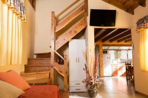 Habitación con cama elevada y nevera. en Cabañas Las Donosas, en San Carlos de Bariloche