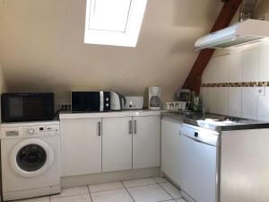 a kitchen with a washing machine and a washer at Les Agapanthes La Riche in La Riche