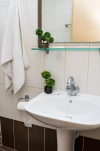 bagno con lavandino bianco e specchio di COSTAS HOTEL a Città di Zante