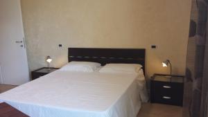 1 dormitorio con 1 cama blanca grande y 2 lámparas en B&B Azzurra, en Pescara