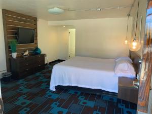 a bedroom with a bed and a flat screen tv at The Sands Motel in Boulder City