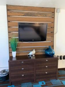 a entertainment center with a tv on top of a wooden wall at The Sands Motel in Boulder City