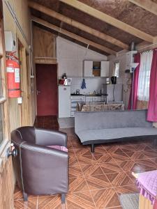 sala de estar con sofá y cocina en Cabañas Kela, en Bahía Murta