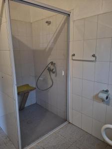 una doccia con una porta in vetro in un bagno di Cabañas Kela a Bahía Murta Altre 37 foto