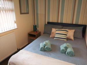 um quarto com uma cama com toalhas em Fearnhead House em Warrington