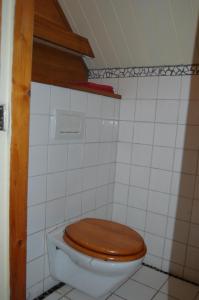 een badkamer met een toilet en een houten toiletbril bij B&B Onze Deel in Hijken