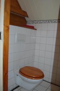 a bathroom with a toilet with a wooden toilet seat at B&B Onze Deel in Hijken