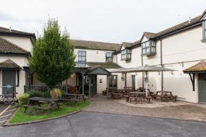 un grupo de edificios con mesas de picnic y sombrillas en Admiral's Table, Bridgwater by Marston's Inns, en Bridgwater