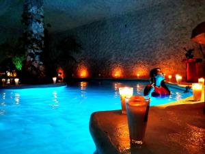 a person sitting in a swimming pool at night at Mayan Majesty Boutique Hotel in Valladolid