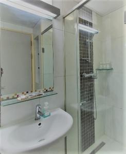 a white bathroom with a sink and a shower at Treehouse in Incheon